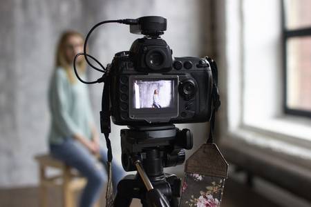 93085238-backstage-with-professional-shooting-in-the-studio-the-model-sits-on-a-chair-a-professional-camera-i